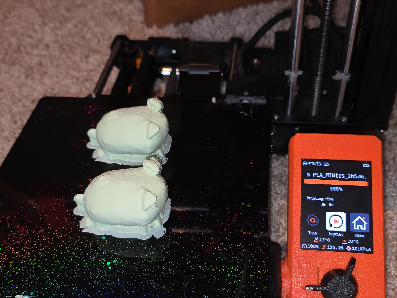 Freshly printed white loaf cat minis on the 3D printer bed