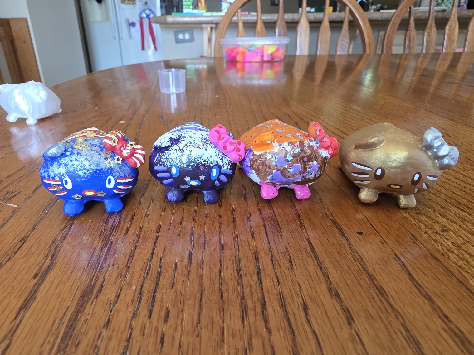 Four hand-painted loaf cat minis lined up side by side, each in a different color scheme
