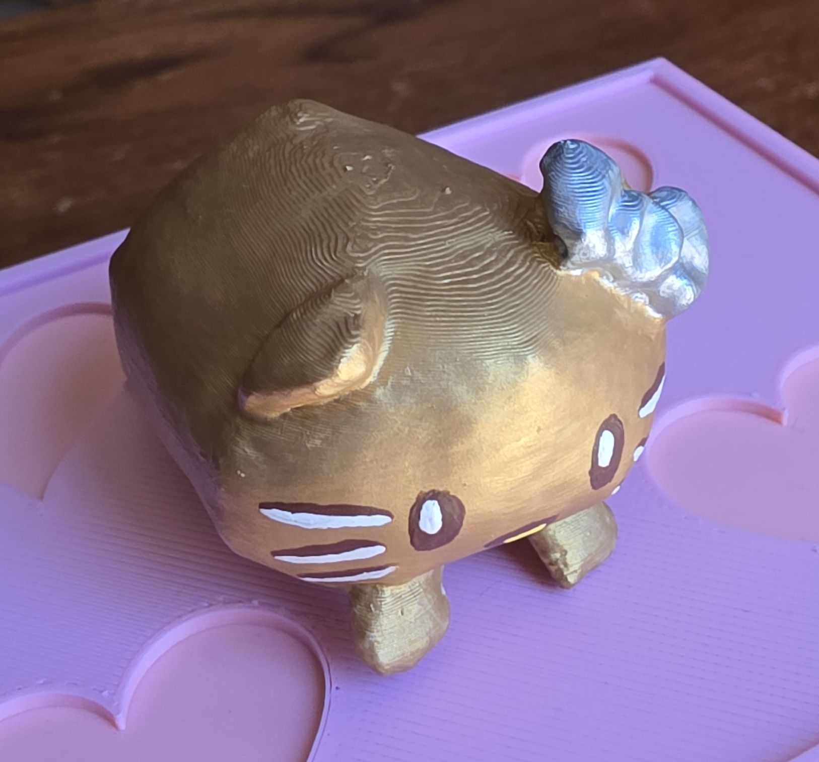 The Gold Nugget Loaf Kitty mini painted gold, from a front-right angle